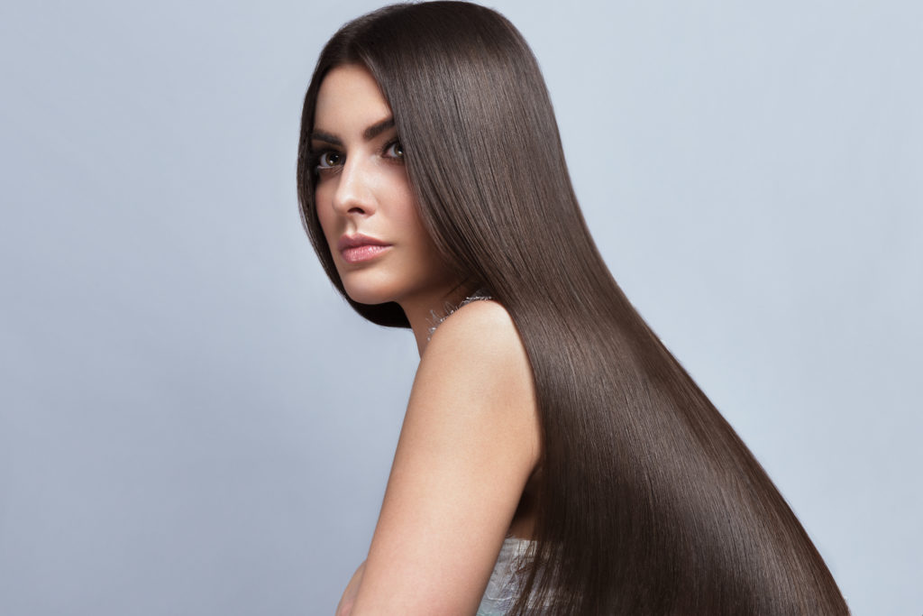 Beautiful brown-haired girl with a perfectly smooth hair, and classic make-up. Beauty face and hair.
